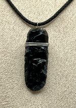Ciondolo in ossidiana naturale intagliata a mano, con cordino nero regolabile.